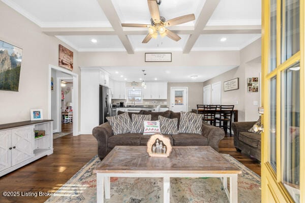 living room featuring dark hardwood / wood-style floors, beamed ceiling, ornamental molding, coffered ceiling, and ceiling fan