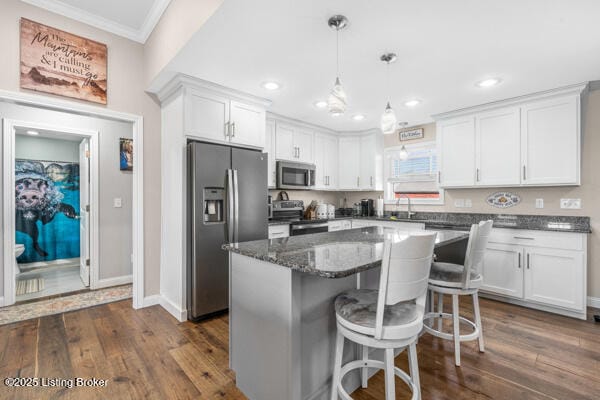 kitchen featuring stainless steel appliances, a kitchen island, white cabinets, and dark hardwood / wood-style flooring