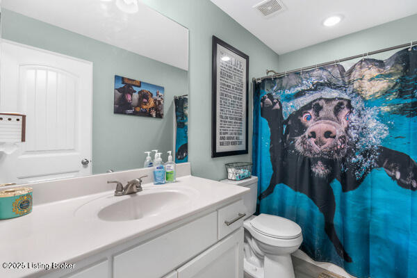 bathroom featuring a shower with curtain, vanity, and toilet