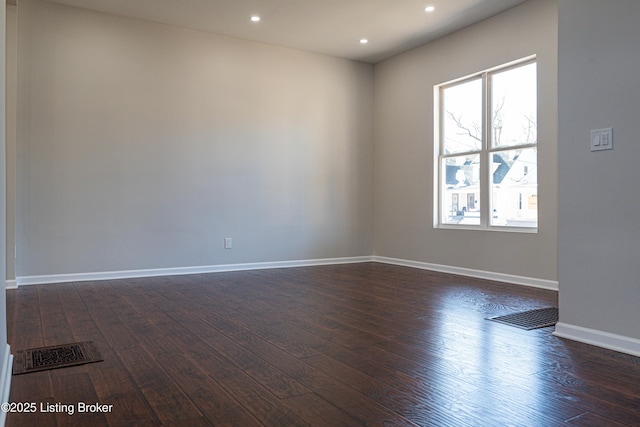 unfurnished room with dark wood-type flooring