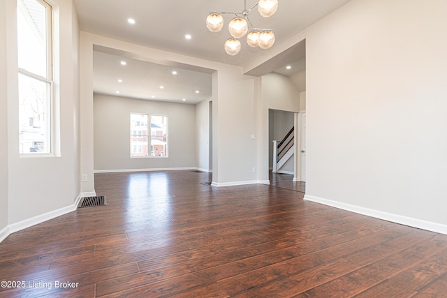 unfurnished living room with dark hardwood / wood-style floors and a chandelier