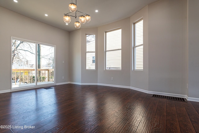 unfurnished room featuring dark hardwood / wood-style flooring and an inviting chandelier