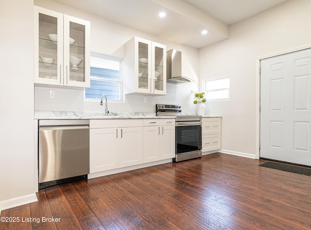 kitchen with wall chimney range hood, sink, white cabinetry, stainless steel appliances, and dark hardwood / wood-style flooring