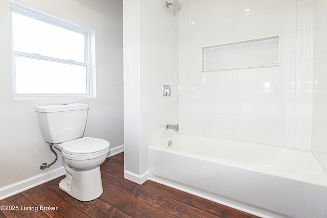 bathroom with toilet, tiled shower / bath combo, and hardwood / wood-style floors