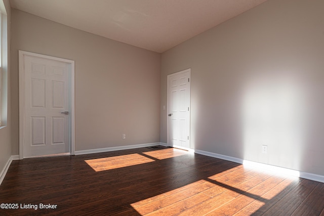 empty room with dark hardwood / wood-style floors