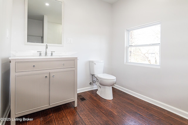 bathroom featuring wood-type flooring, toilet, and vanity