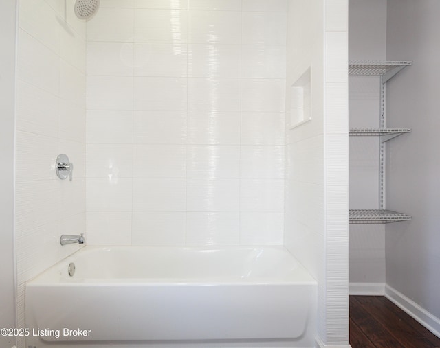 bathroom with tiled shower / bath combo and hardwood / wood-style floors