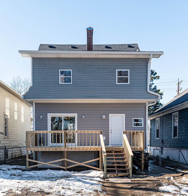 snow covered house with a wooden deck