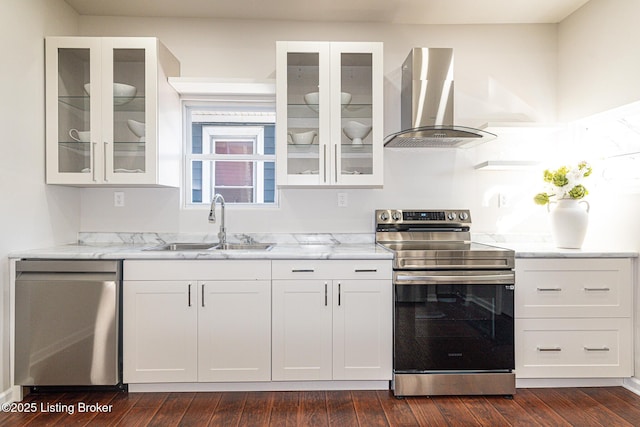 kitchen featuring range hood, white cabinetry, sink, light stone counters, and stainless steel appliances