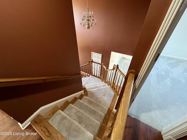 staircase featuring hardwood / wood-style flooring and a chandelier