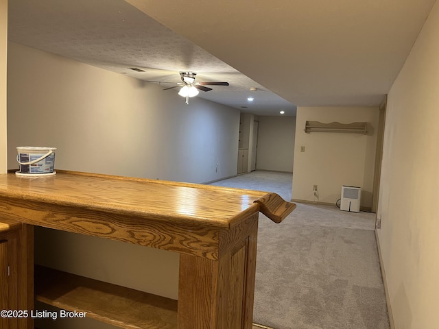 bar featuring ceiling fan, light carpet, and a textured ceiling