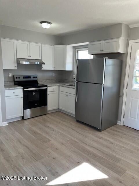 kitchen with white cabinetry, appliances with stainless steel finishes, and light hardwood / wood-style flooring