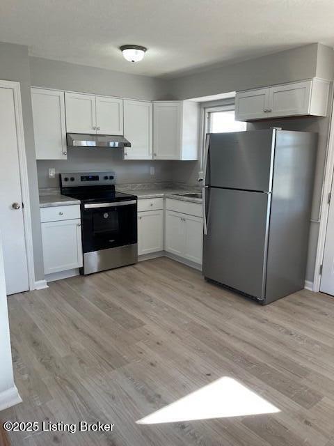 kitchen featuring white cabinetry, appliances with stainless steel finishes, sink, and light wood-type flooring