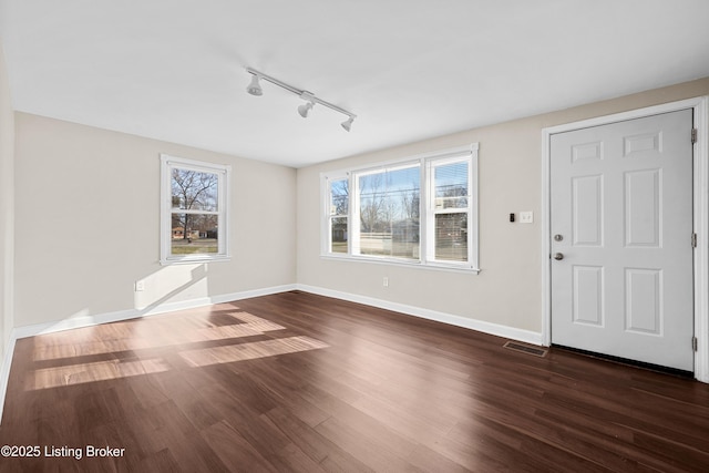 interior space featuring dark wood-type flooring and rail lighting