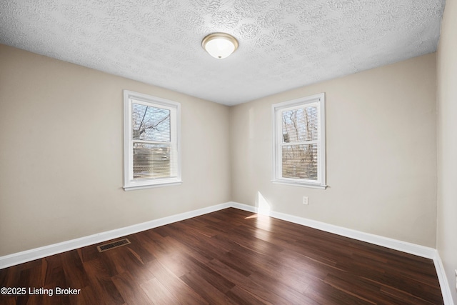 unfurnished room featuring wood-type flooring and a textured ceiling