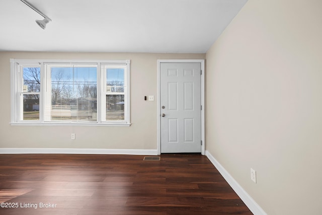 foyer featuring rail lighting and dark hardwood / wood-style floors