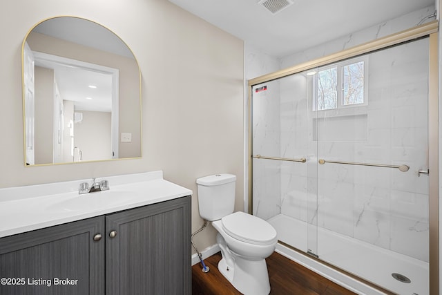 bathroom with vanity, wood-type flooring, a shower with door, and toilet