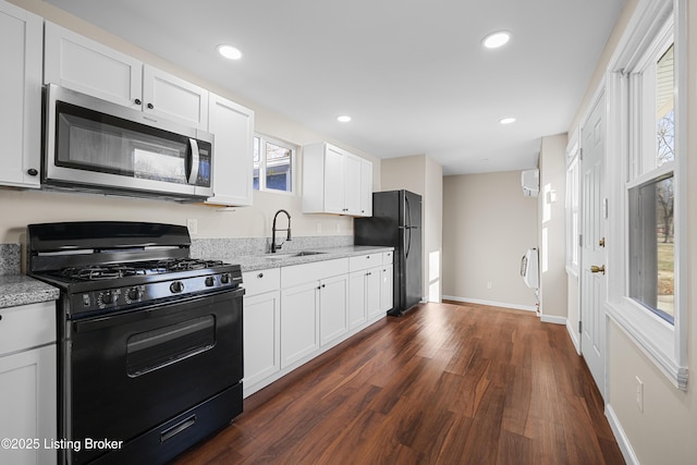 kitchen featuring dark wood-type flooring, sink, black appliances, light stone countertops, and white cabinets