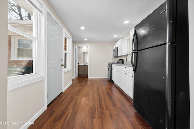 kitchen featuring white cabinetry, appliances with stainless steel finishes, and dark hardwood / wood-style floors