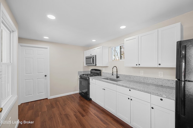 kitchen featuring sink, light stone counters, black appliances, dark hardwood / wood-style floors, and white cabinets