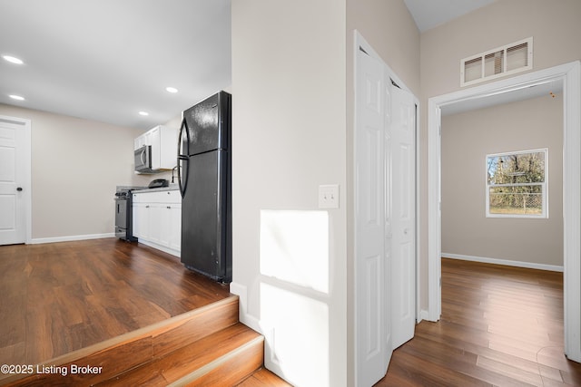 interior space with stainless steel appliances, white cabinetry, and dark hardwood / wood-style floors