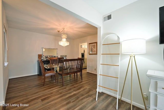 dining space featuring a notable chandelier and dark hardwood / wood-style floors