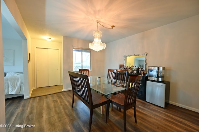 dining space featuring dark hardwood / wood-style flooring and a chandelier