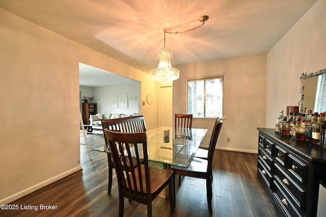 dining space with dark hardwood / wood-style floors and a chandelier