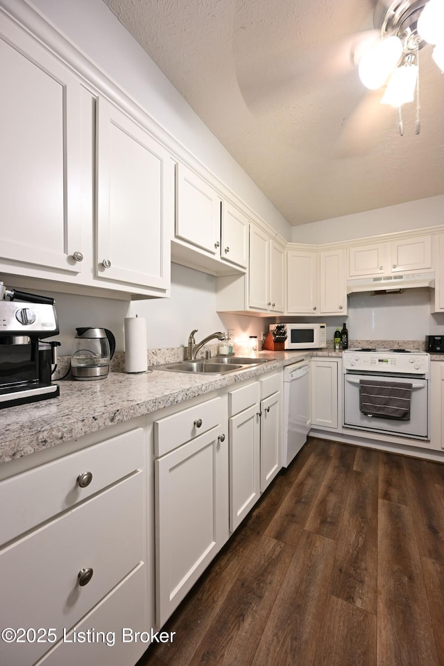 kitchen with white cabinetry, dark hardwood / wood-style flooring, sink, and white appliances