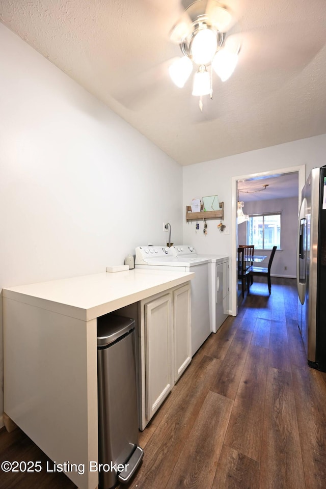 laundry area featuring ceiling fan, cabinets, independent washer and dryer, a textured ceiling, and dark hardwood / wood-style flooring