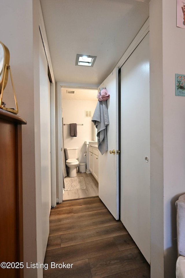 hallway with dark hardwood / wood-style flooring