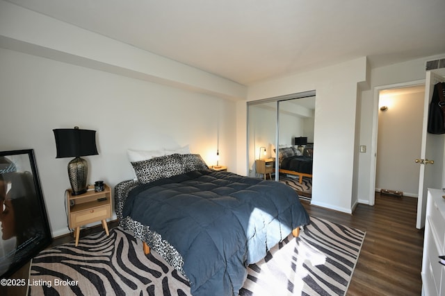 bedroom with dark hardwood / wood-style flooring and a closet