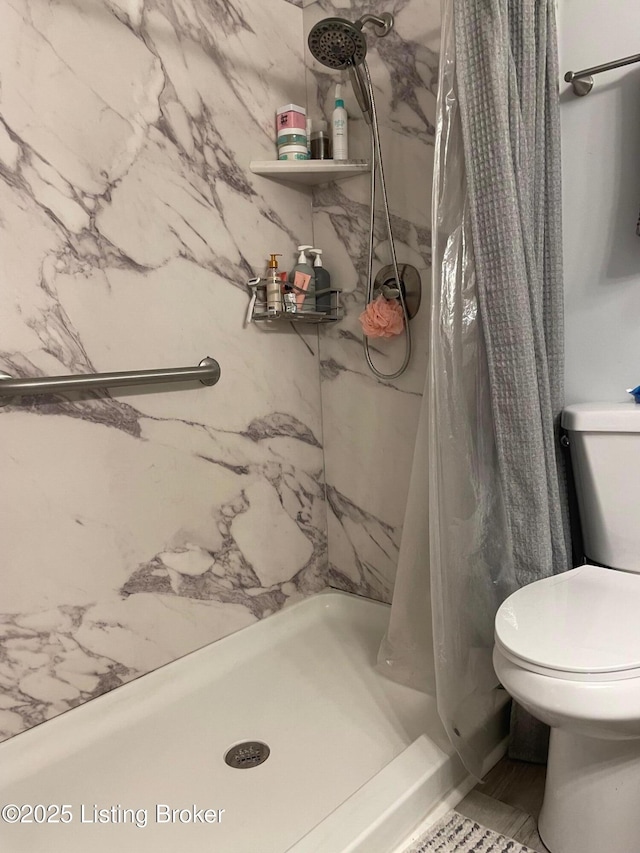 bathroom featuring toilet and a shower with shower curtain