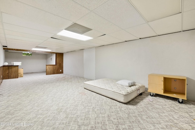 basement with carpet floors and a paneled ceiling