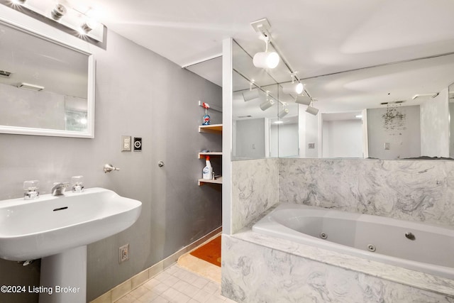 bathroom with tiled tub and tile patterned flooring