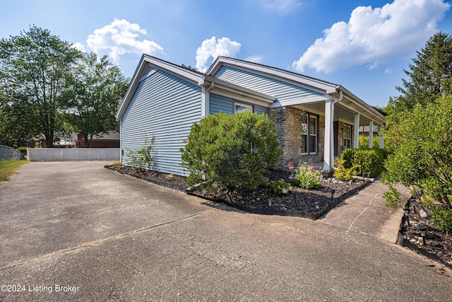 view of side of home featuring covered porch