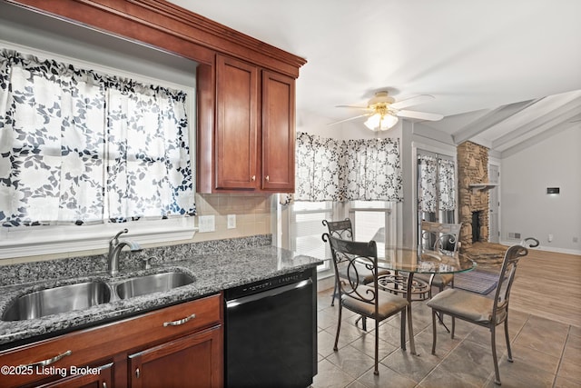 kitchen with sink, vaulted ceiling, black dishwasher, ceiling fan, and dark stone counters