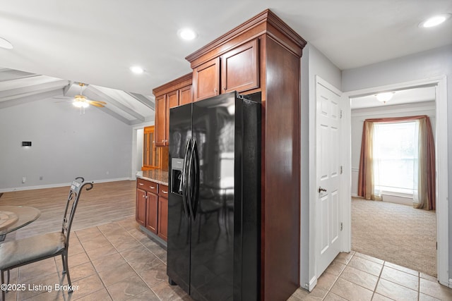 kitchen with ceiling fan, light stone countertops, lofted ceiling with beams, black fridge, and light carpet