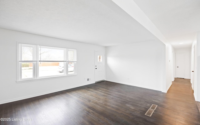 spare room with dark hardwood / wood-style flooring and a textured ceiling