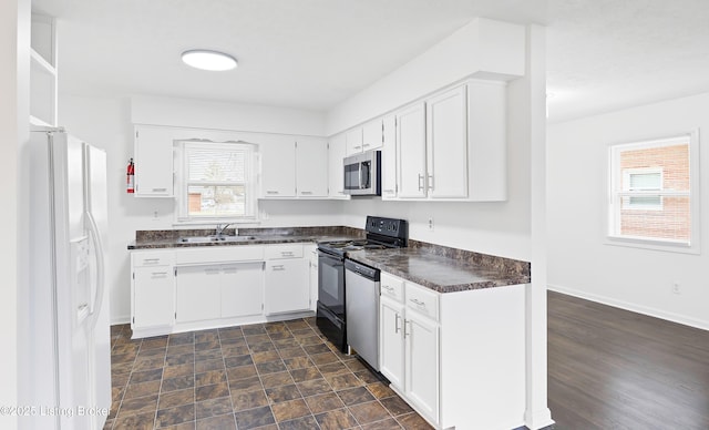 kitchen featuring stainless steel appliances, white cabinetry, and sink