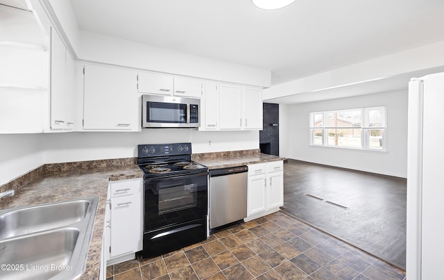 kitchen featuring stainless steel appliances, white cabinetry, and sink