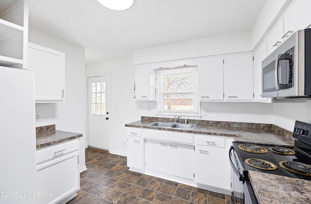 kitchen with white refrigerator, white cabinetry, black electric range, and sink