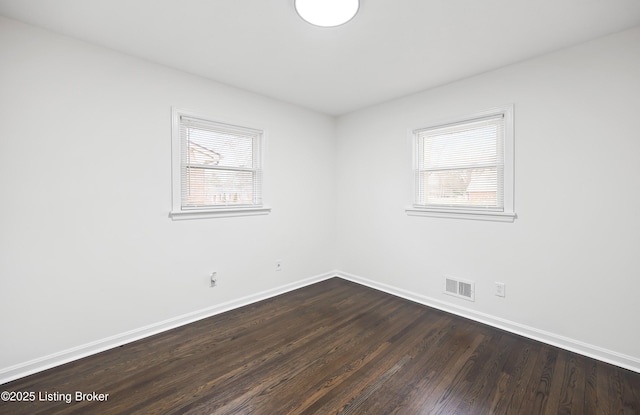 empty room with dark wood-type flooring and plenty of natural light