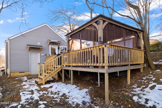 snow covered house with a deck