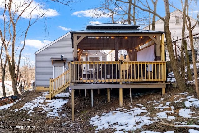 snow covered property with a gazebo and a wooden deck