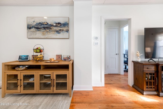 hallway featuring crown molding and light wood-type flooring