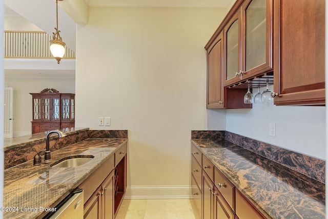 kitchen with stainless steel dishwasher, sink, light tile patterned floors, and dark stone counters