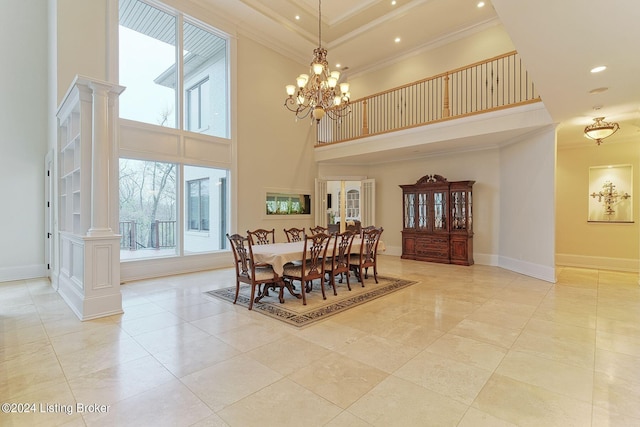 dining room featuring a high ceiling, crown molding, decorative columns, and a chandelier