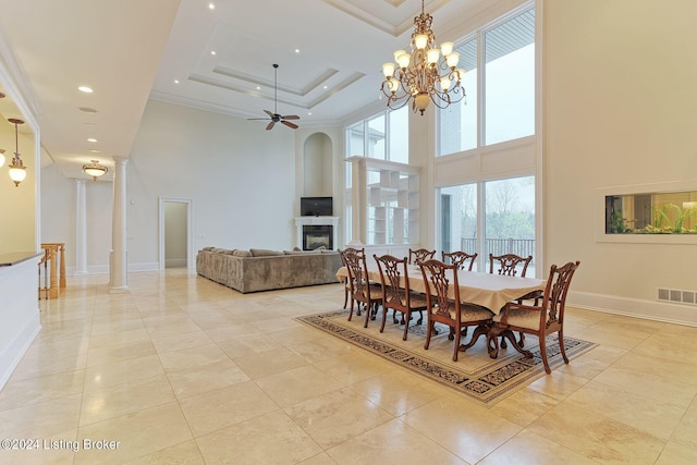 dining room featuring crown molding, a towering ceiling, and ornate columns