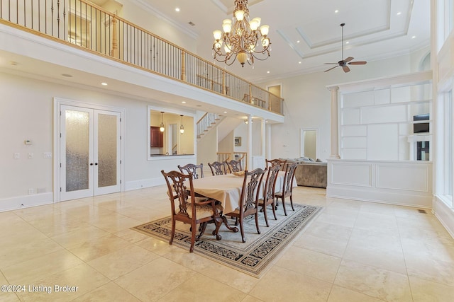 dining area featuring light tile patterned floors, a towering ceiling, ornamental molding, french doors, and a raised ceiling